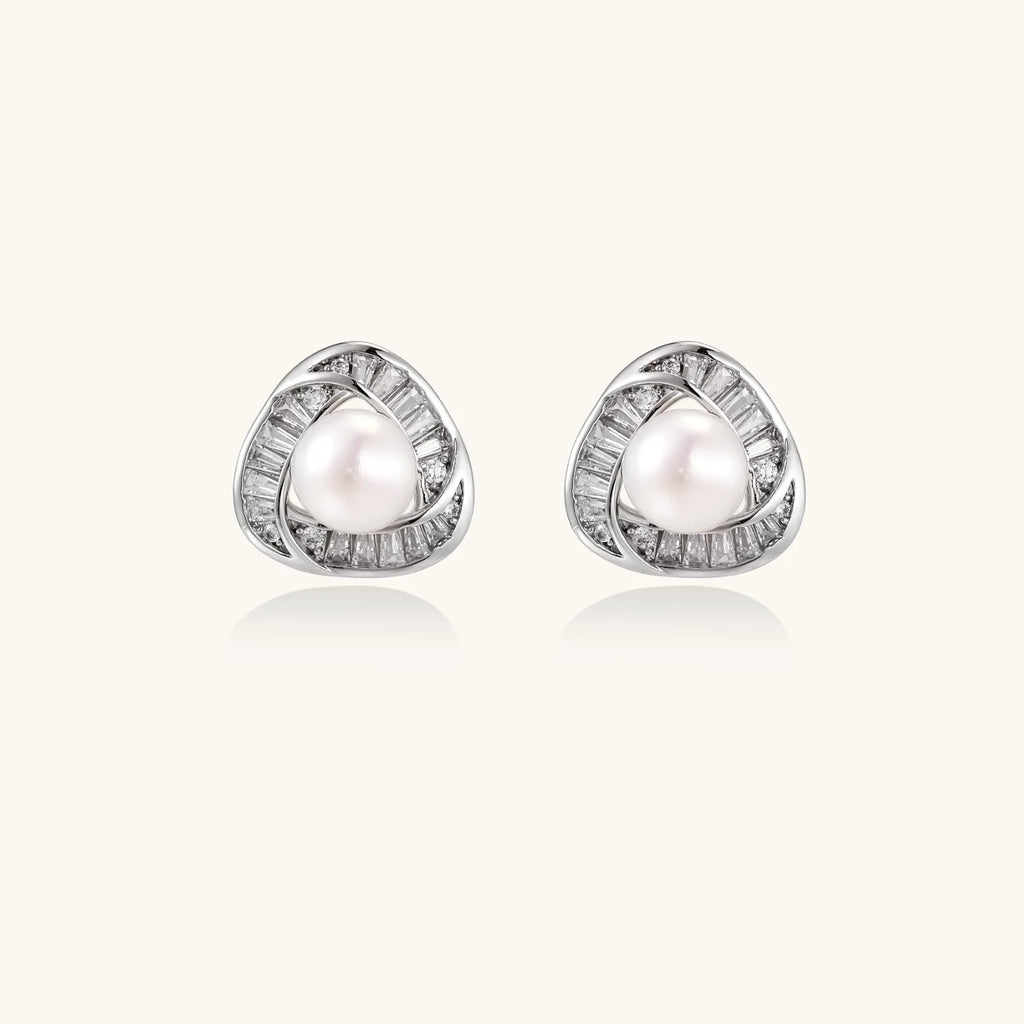 Triangular white gold plated stud earrings with central freshwater pearl and baguette-cut stones on white background