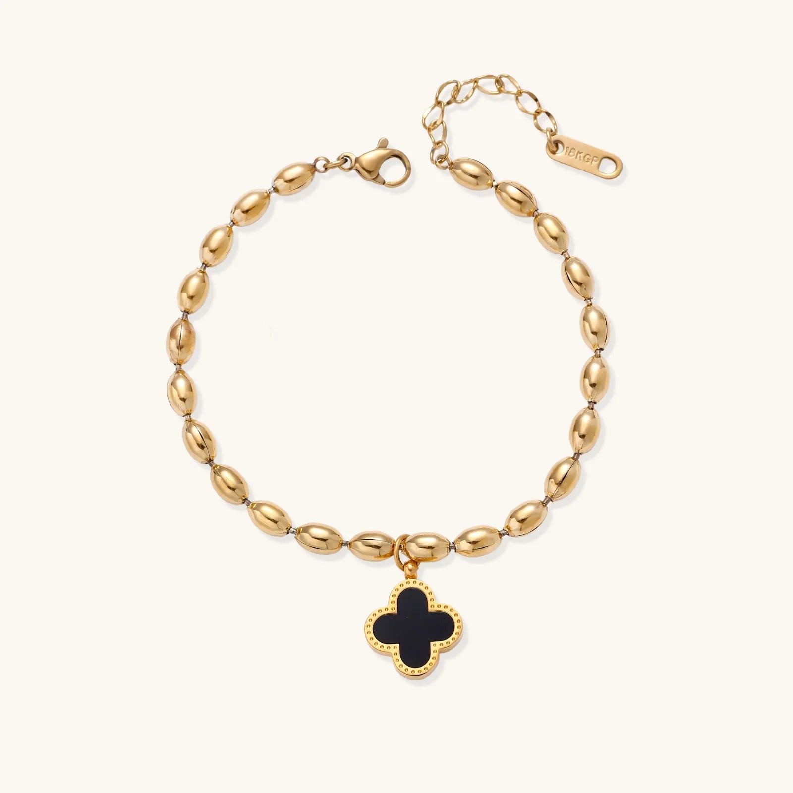 18K gold-plated oval bead chain bracelet with quatrefoil clover charm featuring mother of pearl inlay on cream background