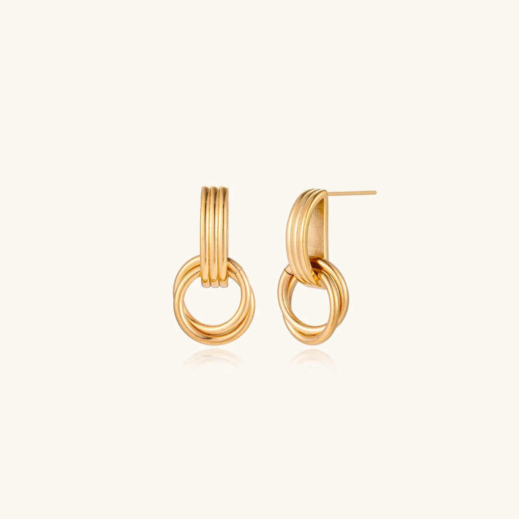 Gold stud earrings with vertical ridged bar connecting to triple interlocking circular rings on white background