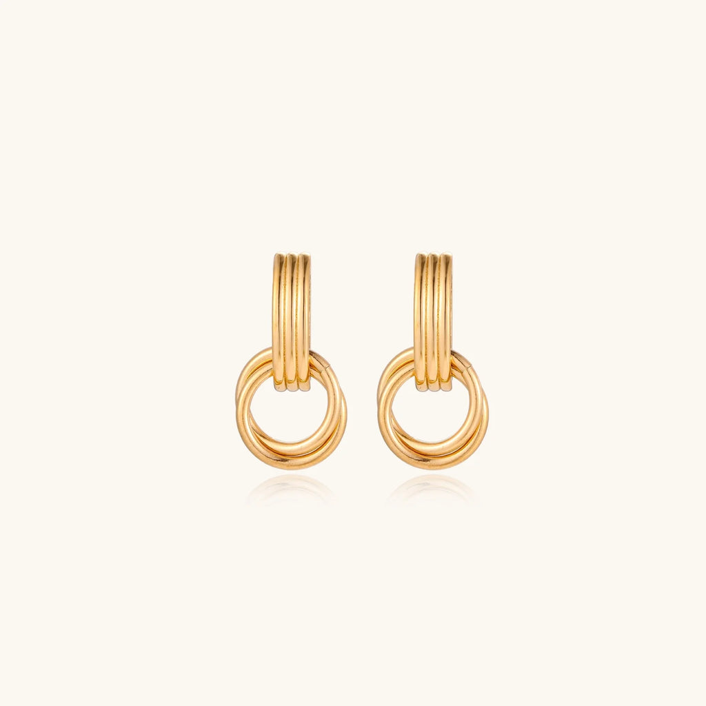 Gold stud earrings with vertical ridged bar connecting to triple interlocking circular rings on white background
