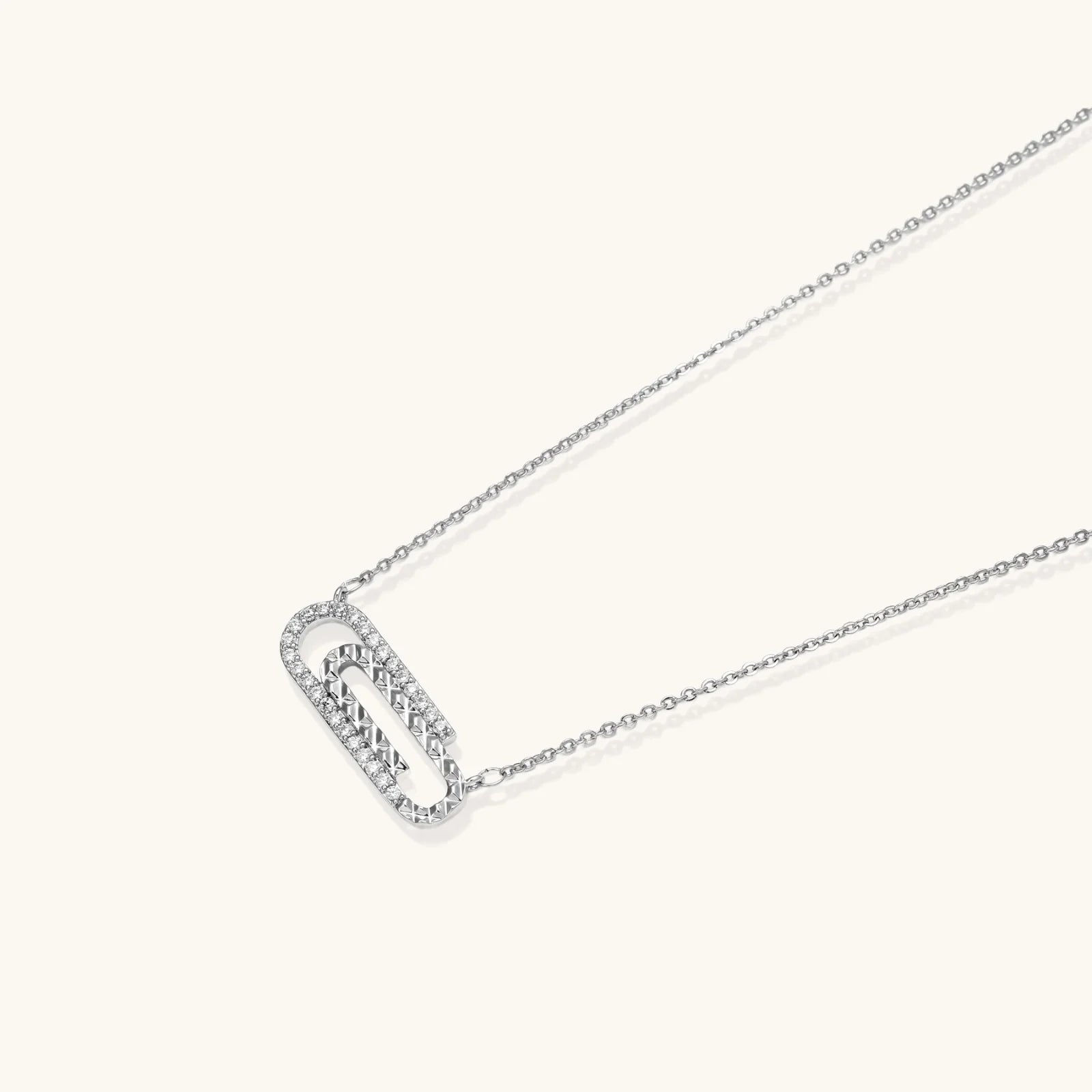 White gold plated necklace with dual-frame geometric pendant featuring crystal pavé border on pale background.